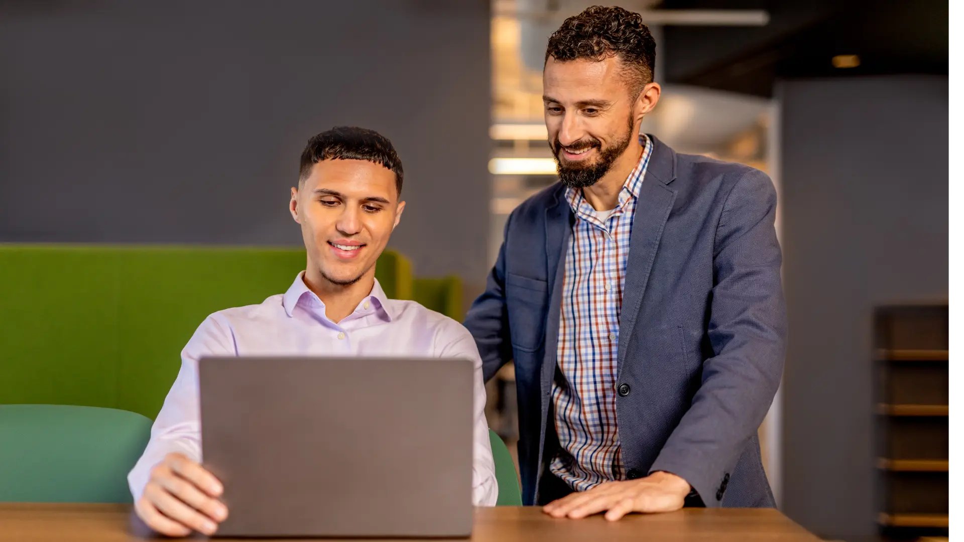 Hero image screenshot of two employees smiling at their work